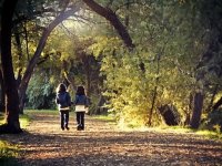 Two youngs girls walking through trees holding hands