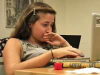 A closeup of a teenage student sitting and working on her laptop.