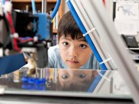 Boy looking at a printer