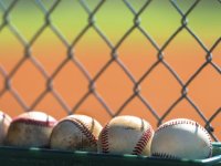 Photo of baseballs against a fence