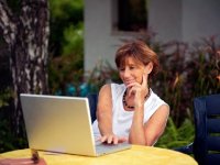 Woman with laptop sitting on a patio
