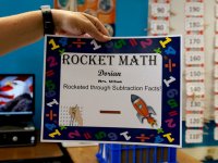 Teacher holding up Dorian's Rocket Math certificate that says he rocketed through subtraction facts
