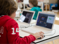 An elementary student working on a laptop