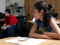 Girl sitting at desk looking towards another student