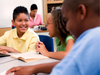 A group of elementary school children in conversation and smiling