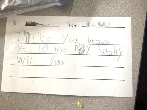 A note from one young student in the writer’s class to another that says, 'I like you because you let me play family with you.'