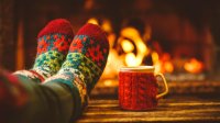 Photo of feet in socks propped up in front of a fire