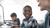 A boy looks up at his teacher with a smile.