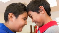 Two boys look into each other's eyes, a technique that builds empathy.