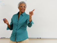 Woman in front of white board holding pen