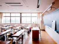 Traditional classroom with desks in rows facing teacher's desk in front of the blackboard