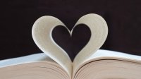Photo of an open book with two pages curled to resemble a heart