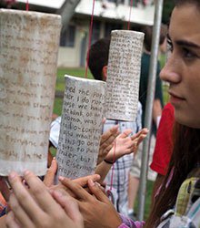 A photo of a female student next to one of the art project pieces.