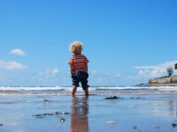 Young boy wading in the ocean