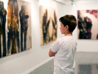 Boy in a museum looking at a painting