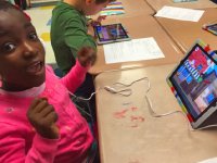 Young girl excited to be working on a tablet