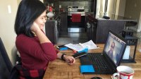 Woman participating in a group video meeting at home