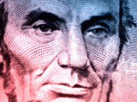 A closeup of president Lincoln's red, blue, and purple face on the five-dollar bill. 