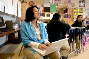 Principal Kimi Kean sitting in class amongst students with her laptop