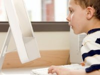 Young boy looking at a computer monitor