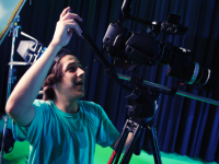 Boy filming using a very large camera