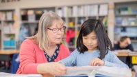 Grandmother reading to child at school. 