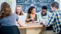 Diverse high school students studying together in class