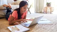 Girl studying with her laptop with drawing materials beside her