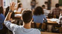 High school student raises his hand in class