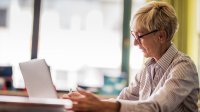 Woman teacher working on laptop at school