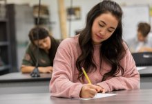 Students in a classroom writing on pieces of paper