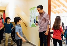 Elementary teacher greets students in the morning outside of the the classroom