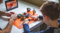 Boy working on a project with modeling clay with his father