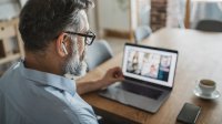 Man has video conference with several people at home 