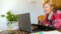 Woman using her laptop at her kitchen table