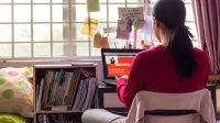 Female teenager working on a distance learning lesson on her laptop at home