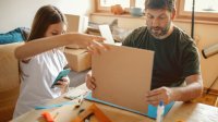 Father and daughter making 3D cardboard models at home