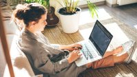 High school student doing homework at home on her laptop