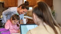 Mother helping her daughters during distance learning classes