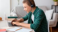 Teen boy working on his laptop at home