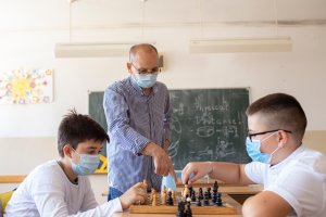 Photo of two boys playing chess at school during COVID-19 pandemic