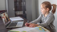 Elementary aged girl participates in distance learning at home