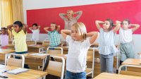 Elementary teacher and students stretch in classroom 