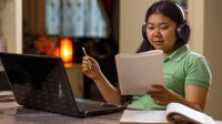 Teenage girl completing school work on her laptop