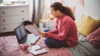 Teen girl participates in distance learning in her bedroom