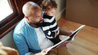 Father reads a picture book to his young son