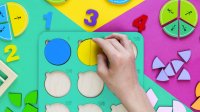 Child's hand works with fraction manipulatives