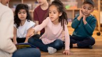 Elementary school teacher reads a picture book to students