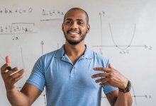 High school math teacher gestures with his hands while lecturing