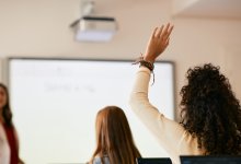 High school student raises hand in classroom